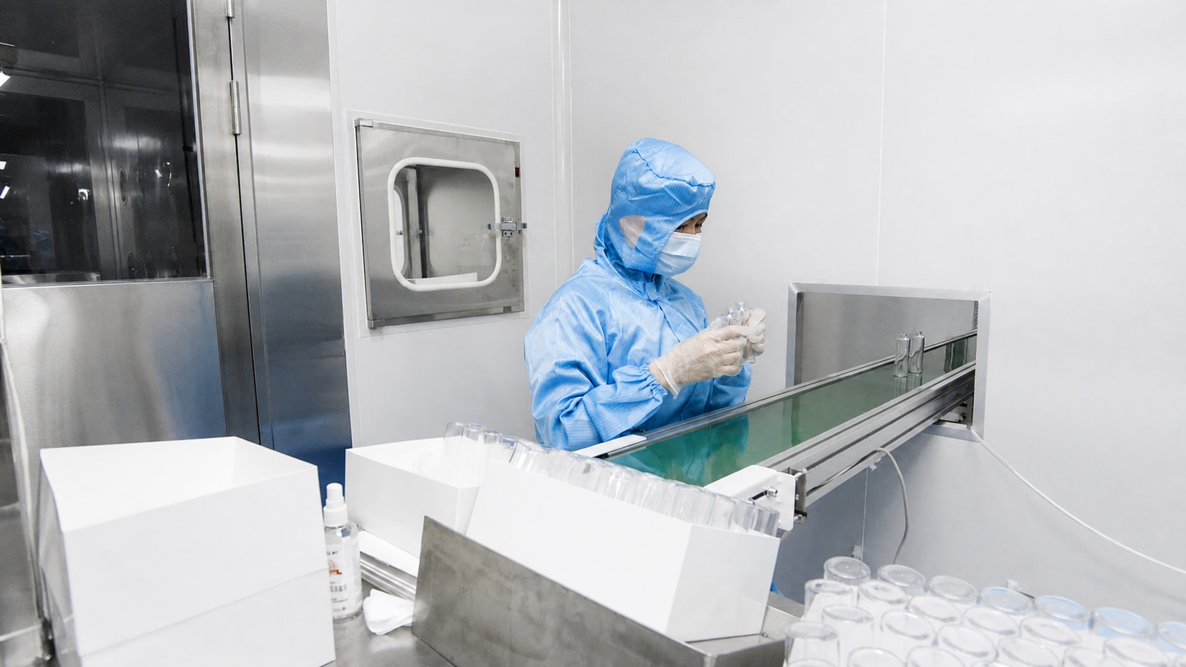 Cleanroom operator inspecting a laboratory plastic container