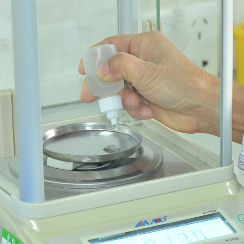 Plastic dispensing bottle being checked on a laboratory balance